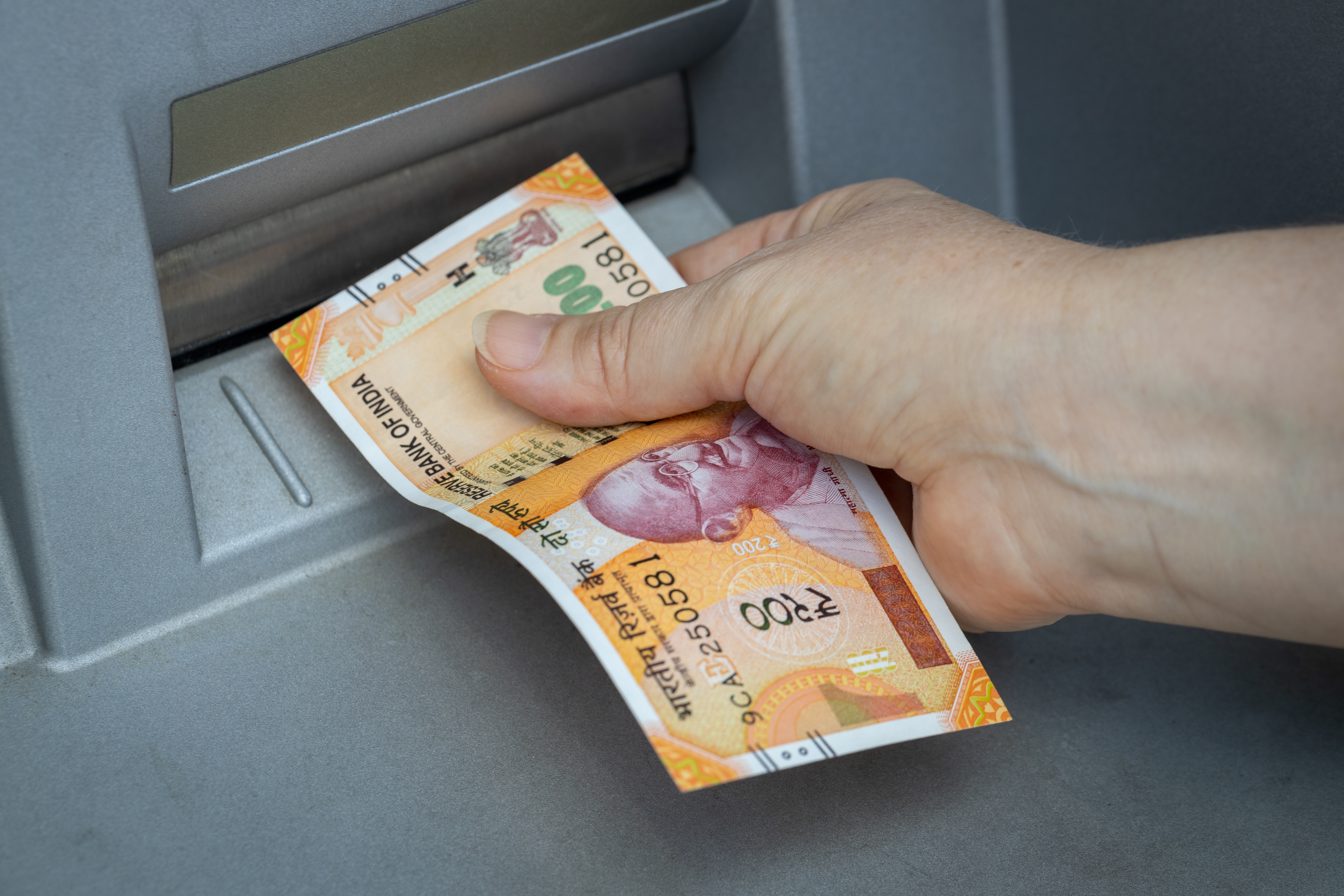 indian cash worth rs. 200 is being withdrawn from atm machine