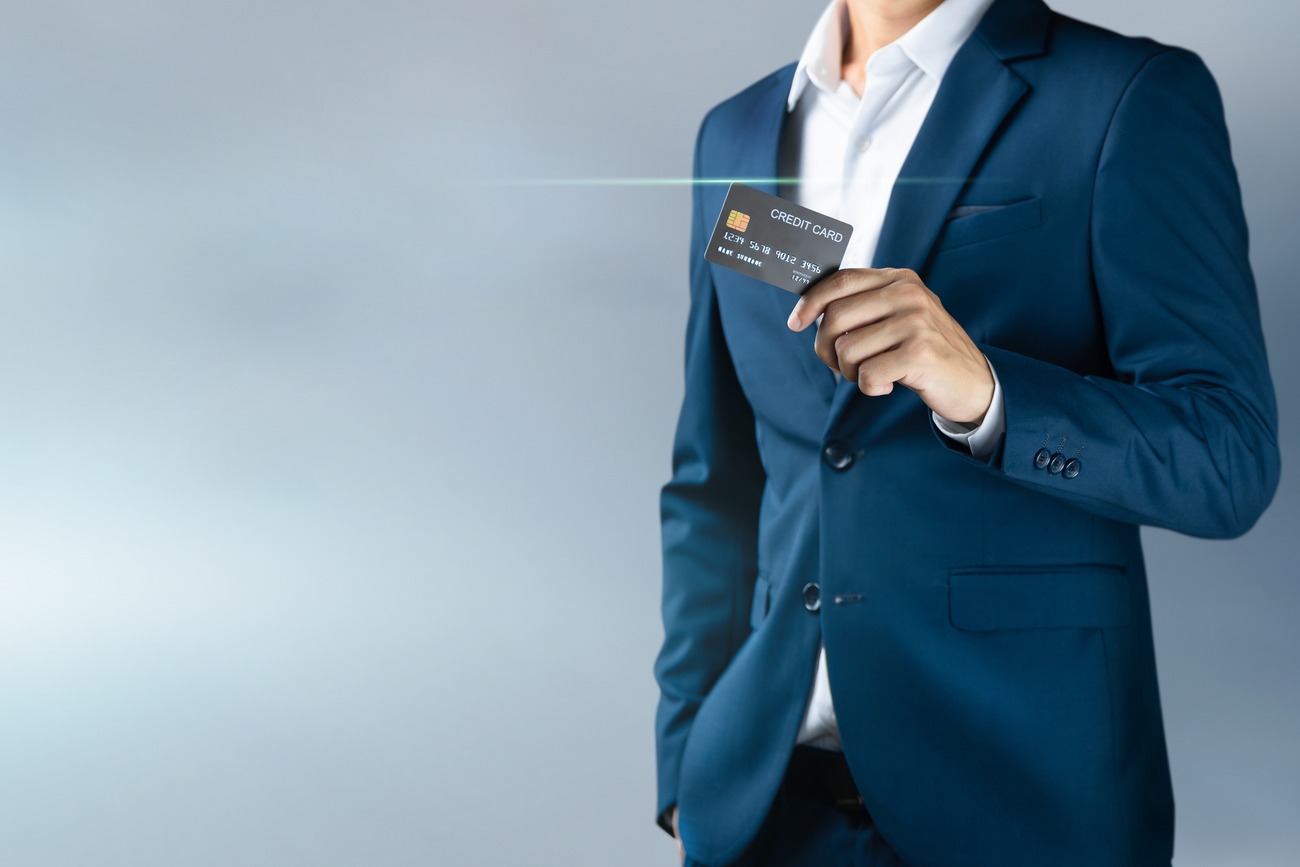 A man in a blue suit carrying a credit card
